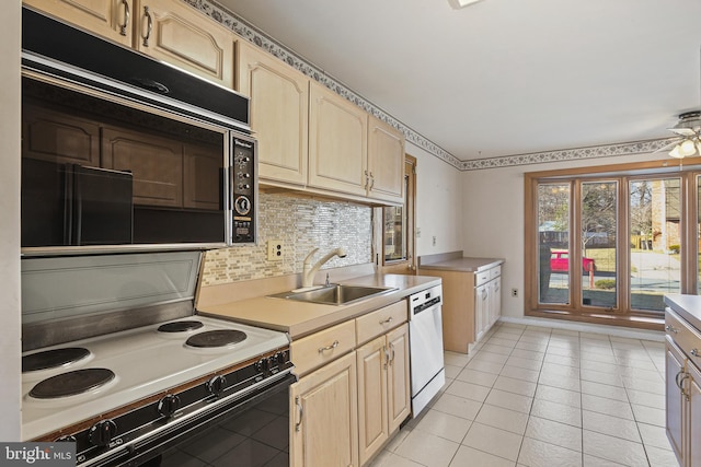 kitchen featuring electric stove, dishwasher, light countertops, light brown cabinetry, and a sink