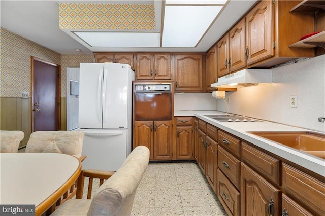 kitchen with wall oven, electric stovetop, sink, and white fridge