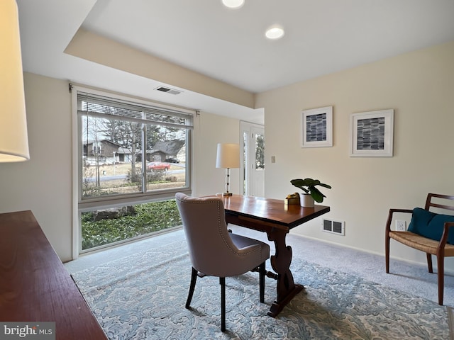 carpeted office with visible vents and baseboards