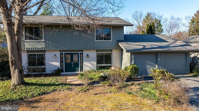 view of front of home with concrete driveway, roof with shingles, and an attached garage