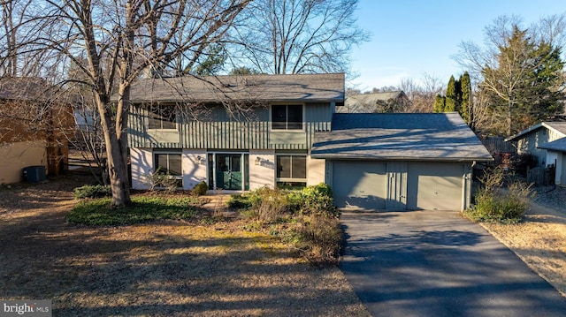 view of front of house featuring driveway, an attached garage, and central AC unit