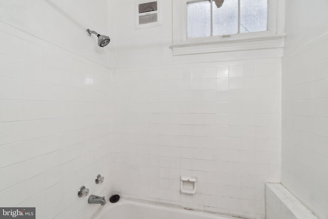 bathroom with washtub / shower combination and visible vents