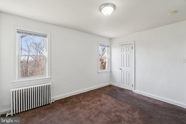 carpeted spare room featuring baseboards, a healthy amount of sunlight, and radiator heating unit