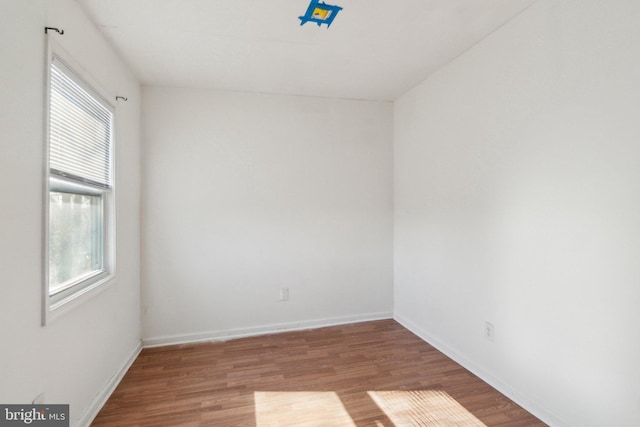 unfurnished room with baseboards and wood finished floors