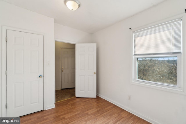 unfurnished bedroom featuring light wood-type flooring and baseboards