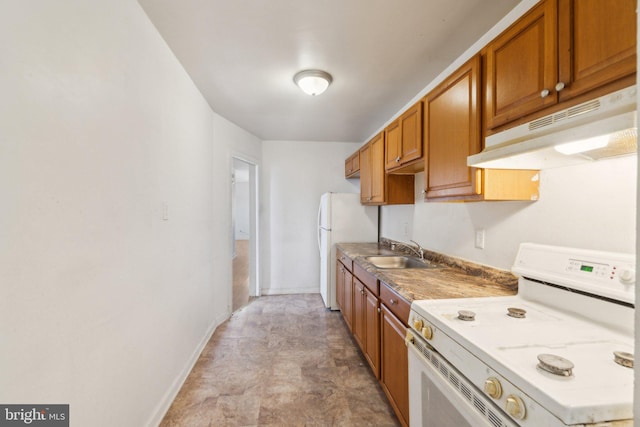 kitchen with brown cabinetry, a sink, white appliances, under cabinet range hood, and baseboards