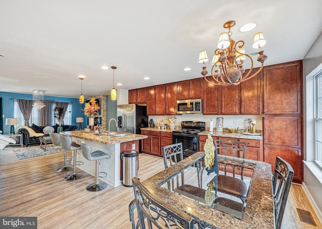 kitchen featuring a notable chandelier, a breakfast bar area, visible vents, light wood-style flooring, and appliances with stainless steel finishes