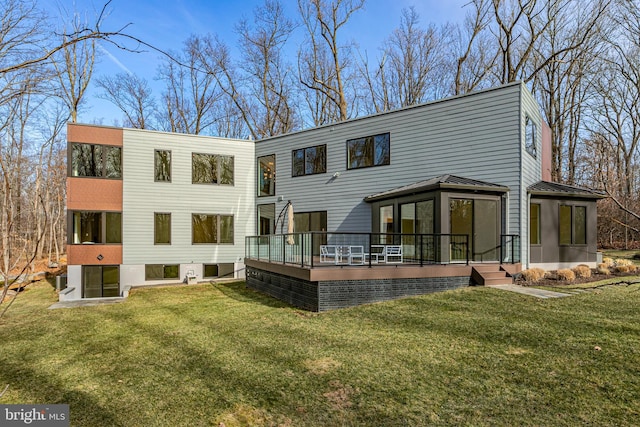 back of house with a lawn, a sunroom, and a deck