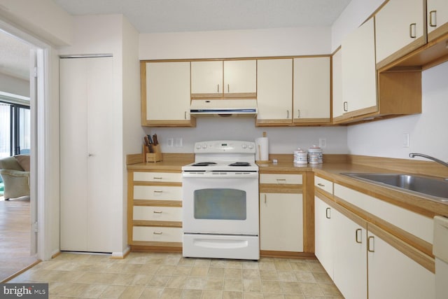 kitchen featuring electric stove, light countertops, a sink, and under cabinet range hood