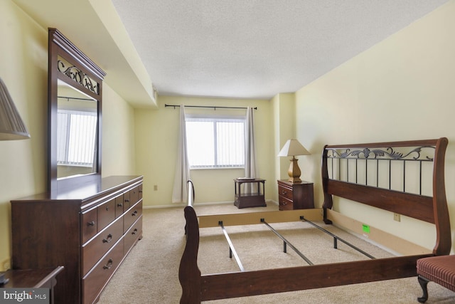 bedroom with light colored carpet, a textured ceiling, and baseboards