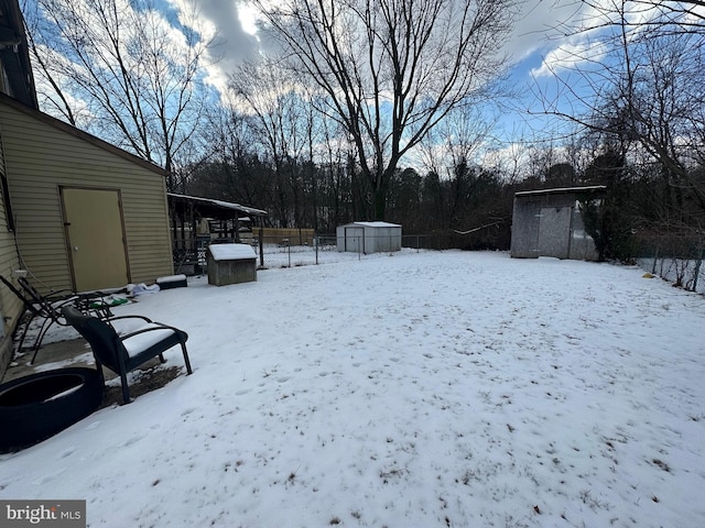 yard layered in snow with a storage shed