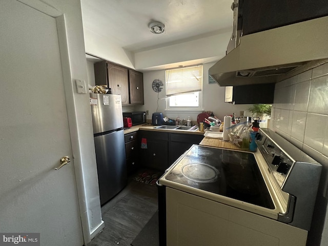 kitchen with sink, extractor fan, dark brown cabinets, stainless steel refrigerator, and range with electric cooktop