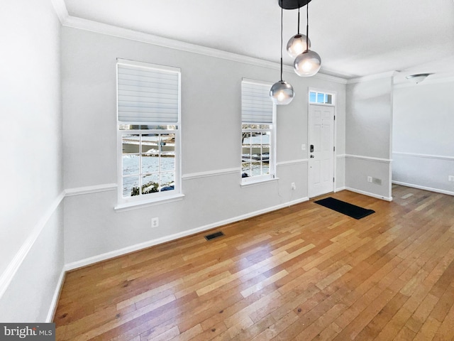 entryway with crown molding, hardwood / wood-style floors, and a wealth of natural light