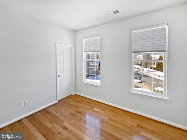 unfurnished room with hardwood / wood-style floors and a wealth of natural light