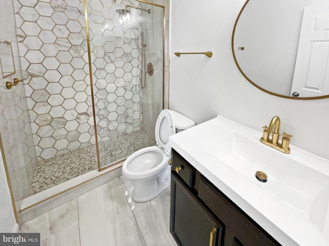 bathroom with vanity, toilet, and tiled shower