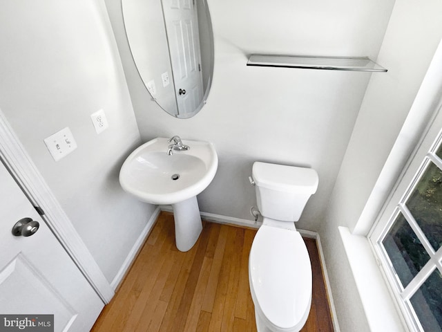 bathroom with wood-type flooring, toilet, and sink