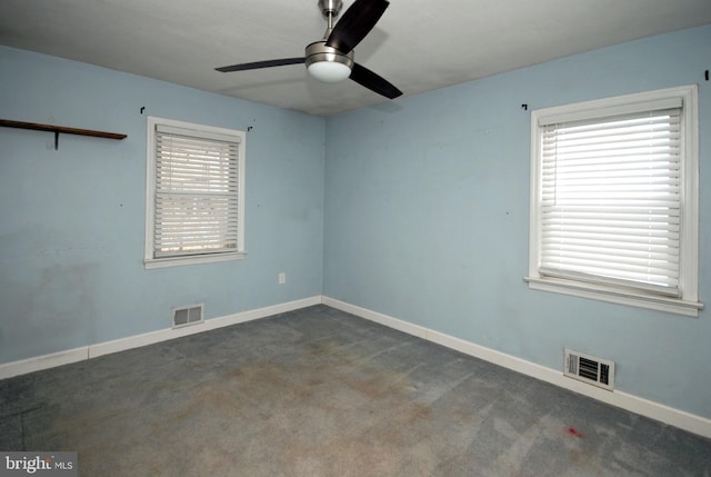 carpeted empty room featuring baseboards, visible vents, and ceiling fan