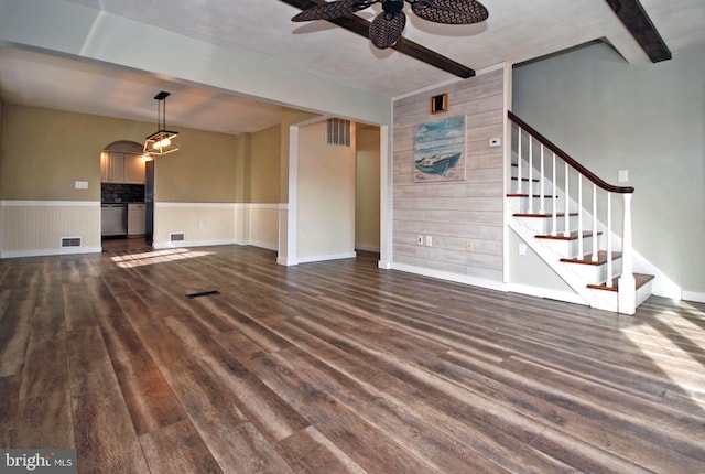 unfurnished living room featuring dark wood-type flooring, beam ceiling, visible vents, and stairway