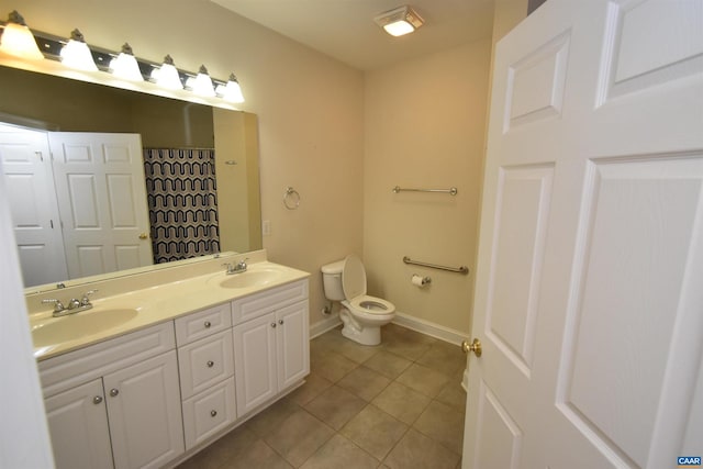 bathroom with tile patterned flooring, vanity, and toilet