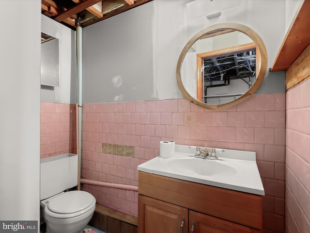 bathroom with vanity, tile walls, and toilet