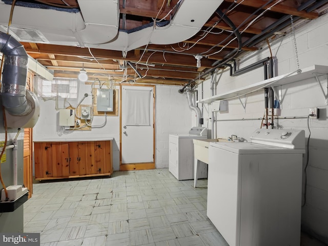 basement featuring sink, electric panel, and washer and clothes dryer