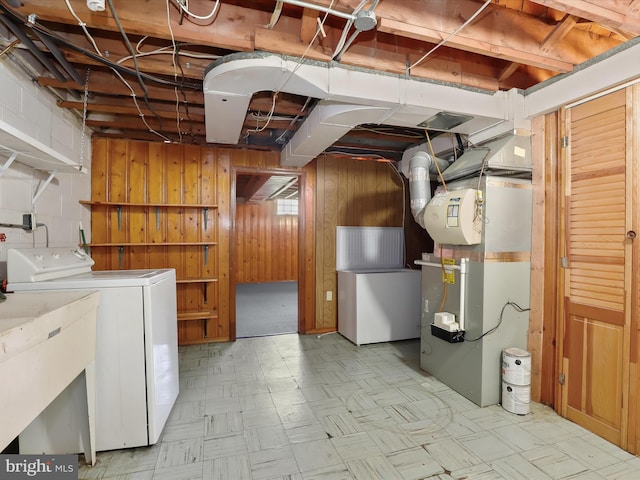 basement with sink, washer / dryer, heating unit, and wood walls