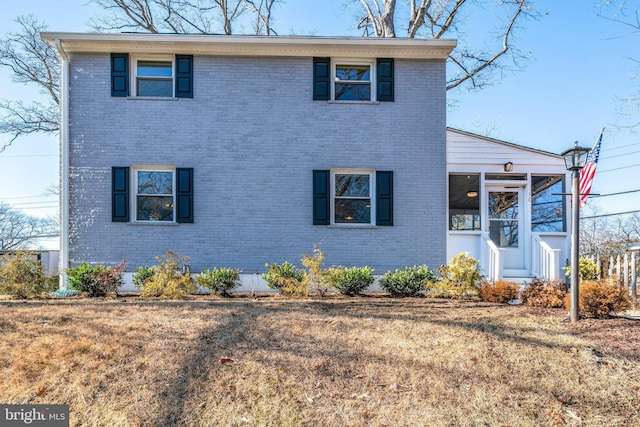 view of front of home with a front yard and brick siding