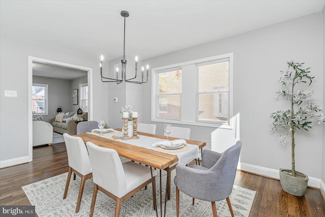 dining space with an inviting chandelier and dark hardwood / wood-style flooring