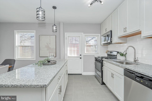 kitchen with stainless steel appliances, a center island, sink, and white cabinets