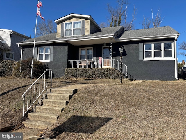 bungalow-style house with covered porch, roof with shingles, stairs, and stucco siding