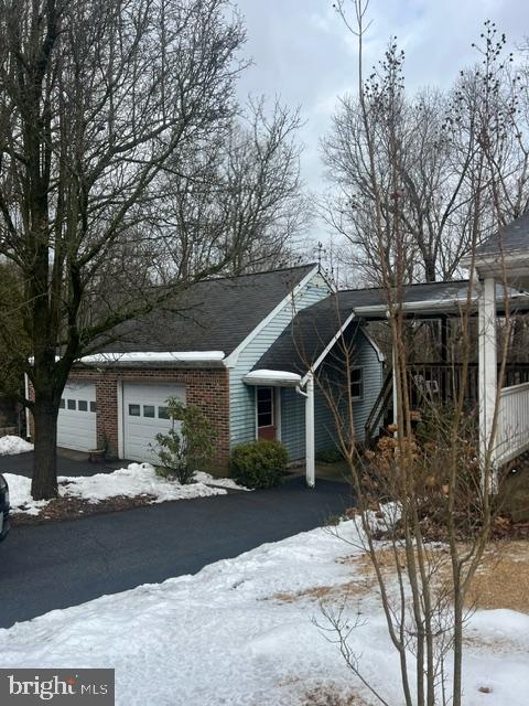 snow covered property with a garage