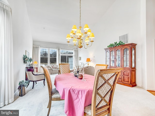 dining area featuring baseboards, visible vents, a notable chandelier, and light colored carpet