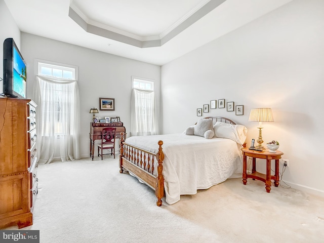 bedroom with ornamental molding, a raised ceiling, multiple windows, and carpet floors