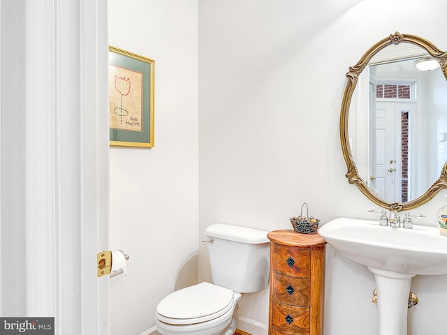 half bathroom with toilet and baseboards