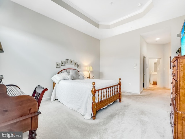 bedroom featuring light carpet, a tray ceiling, ornamental molding, and baseboards