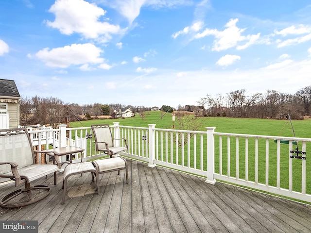 wooden terrace with a rural view and a lawn