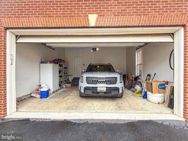 garage with a garage door opener and driveway