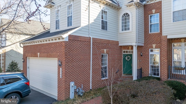 view of home's exterior featuring driveway, a garage, and brick siding