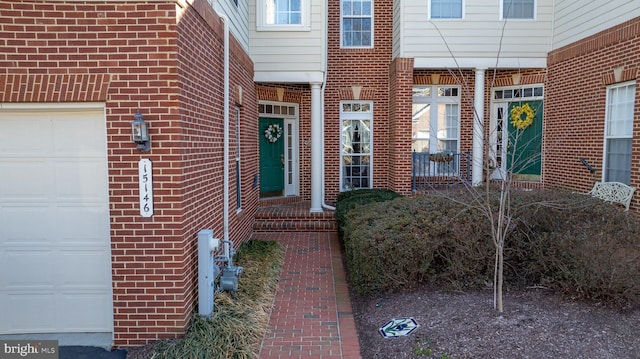 entrance to property with brick siding and an attached garage