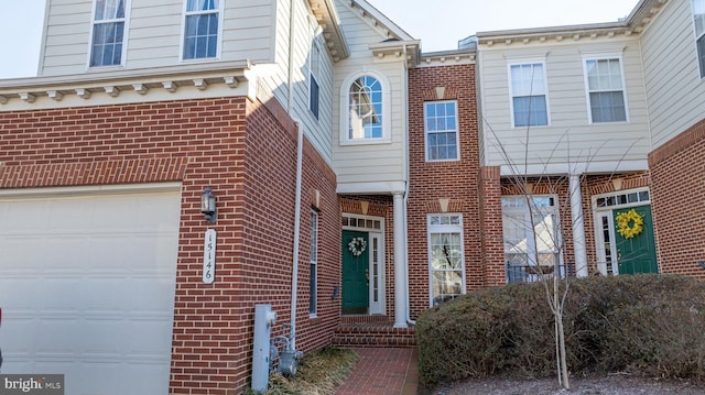 view of front of house with an attached garage and brick siding