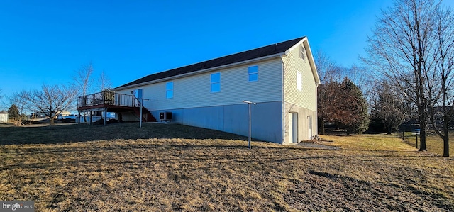 view of side of home with a garage, central AC unit, a lawn, and a wooden deck