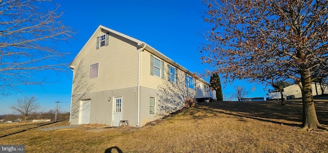 view of property exterior with a yard, an attached garage, and stucco siding