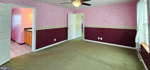 unfurnished room featuring wallpapered walls, a ceiling fan, baseboards, and carpet flooring