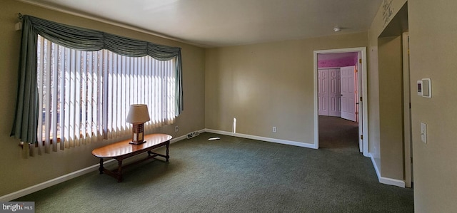 unfurnished room with dark carpet and baseboards