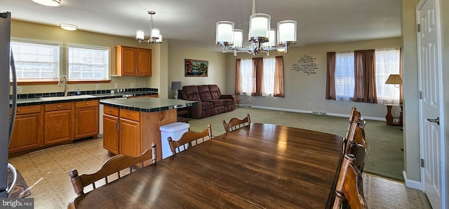 dining space featuring a chandelier, baseboards, and light colored carpet