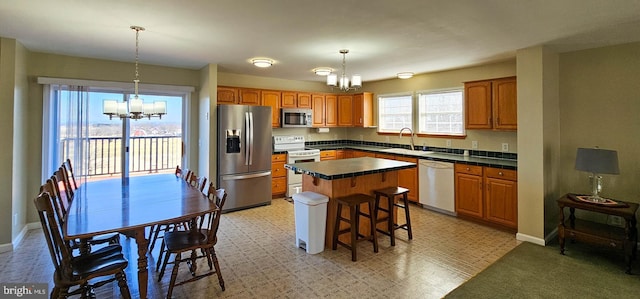 kitchen with an inviting chandelier, stainless steel appliances, and decorative light fixtures