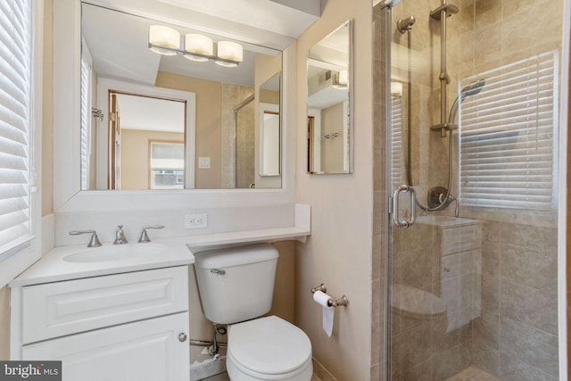 bathroom with vanity, toilet, a healthy amount of sunlight, and a stall shower