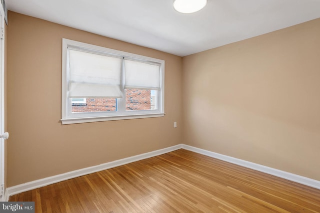 unfurnished room with light wood-style flooring and baseboards