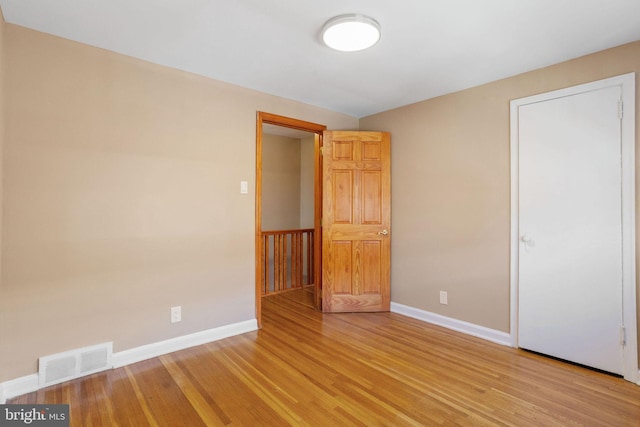 unfurnished bedroom with light wood-style flooring, baseboards, and visible vents