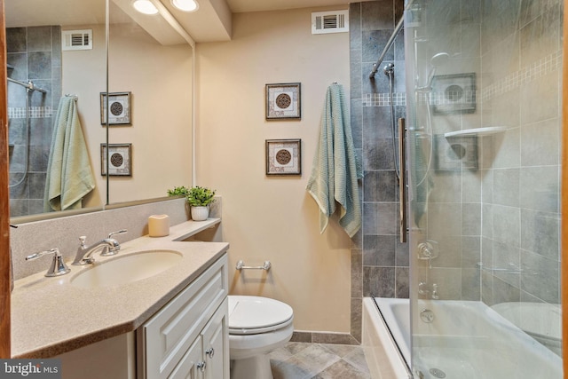 bathroom with enclosed tub / shower combo, visible vents, toilet, and vanity